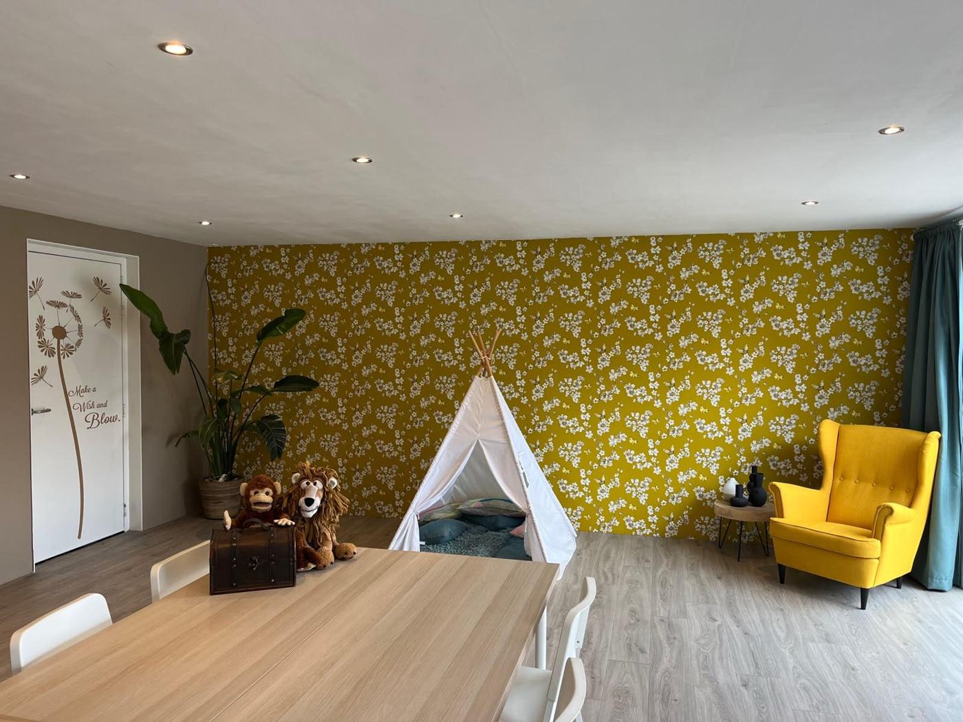 De praktijkruimte met een tipi, knuffels en een gele fauteuil